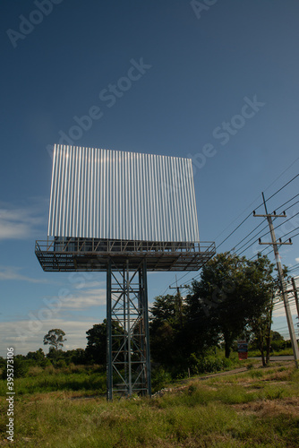 Blank billboard on the background of the road and blue sky. photo