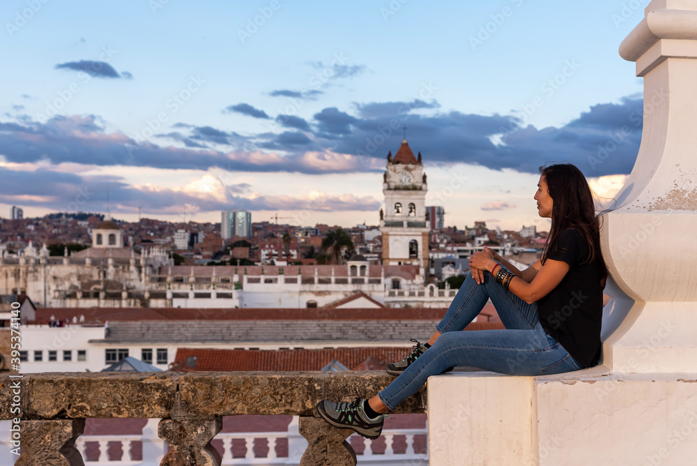 Woman enjoying the views over Sucre and its Belltower from a rooftop at Sucre, Bolivia