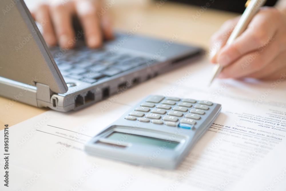Woman's Hands Calculating Home Finances At Desk Woman's Hands Calculating Home Finances At Desk
