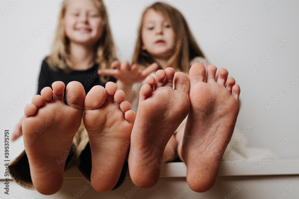 kids-hold-bare-feet-close-up-to-the-camera-their-blurred-giggling