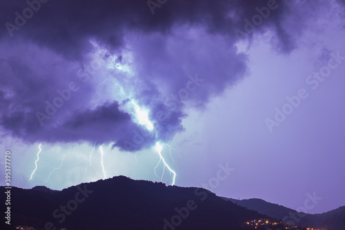 Strong thunder-storm above night mountains and city. Large Bright Lightning Close up. Mediterranian winter night thunderstorm. Alanya, Turkey.