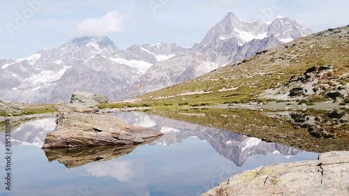 SLOW MOTION:panorama reflection of Mount Matterhorn and Swiss Alps on Riffelsee Lake in Zermatt, Valais, Switzerland. Riffelsee on Riffelseeweg trail, Rotenboden station of Gornergrat Bahn cog railway photo