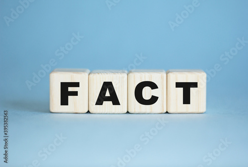 fact. concept. Word written with wooden cubes. Education, medical , quality control. Blue background