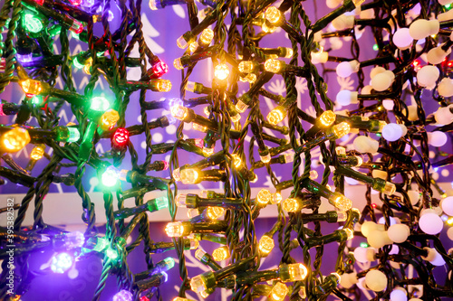 Background image: decorative garlands of multicolored colorful glowing bulbs. Christmas lights