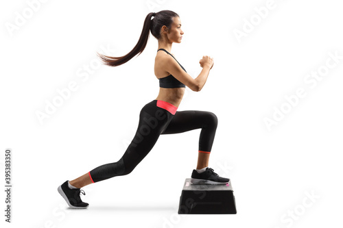 Full length profile shot of a young fit woma exercising step aerobic photo