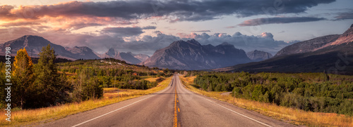 Beautiful View of Scenic Highway with American Rocky Mountain Landscape in the background. Colorful Summer Sunrise Sky. Taken in St Mary, Montana, United States. photo