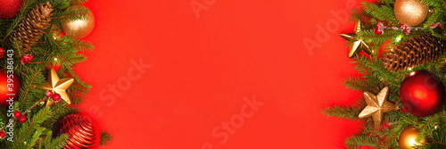 Christmas background with copy space. Festively decorated spruce branches on a red banner. Flat lay style.