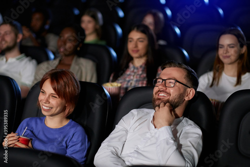Emotional couple watching comedy in movie theater.