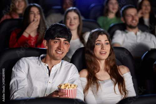 Caucasian couple laughing in movie theater.
