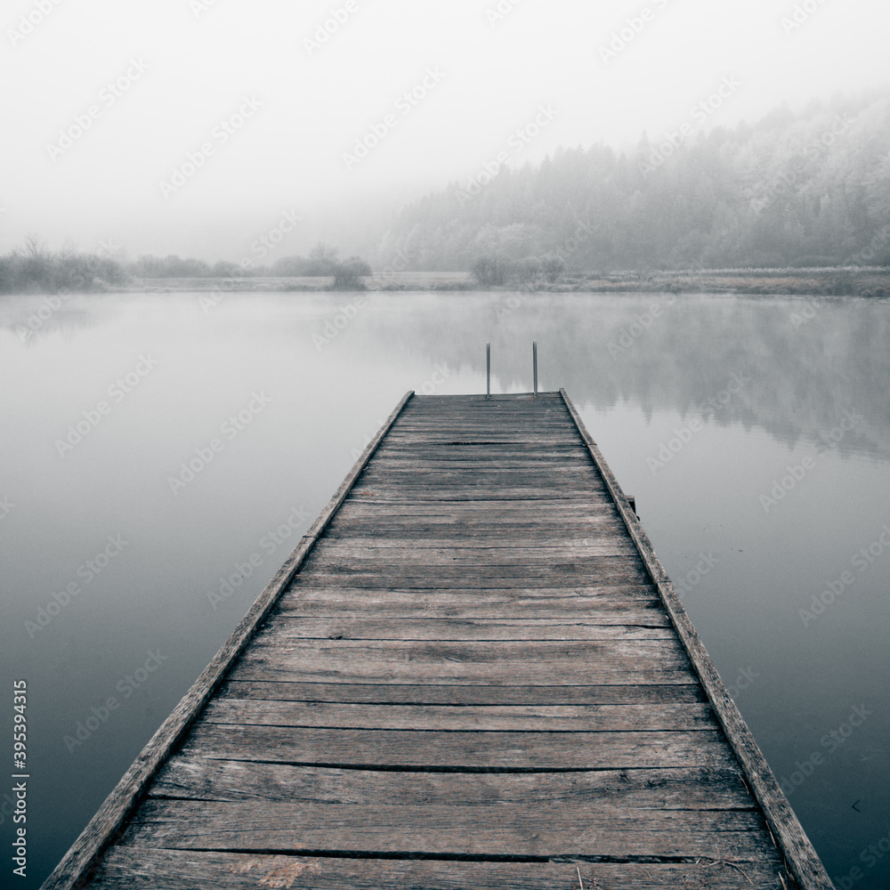 Wooden pier on a frosty lake. Way to hardening.