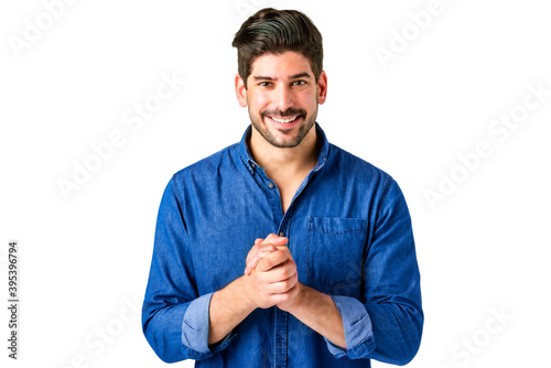 Portrait of casual man standing at isolated white background while looking at camera and laughing