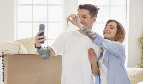 Happy smiling young couple showing a pair of keys of their new house