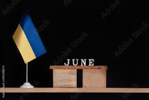 Wooden calendar of June with Ukrainian flag on black background. Dates in Ukraine in June