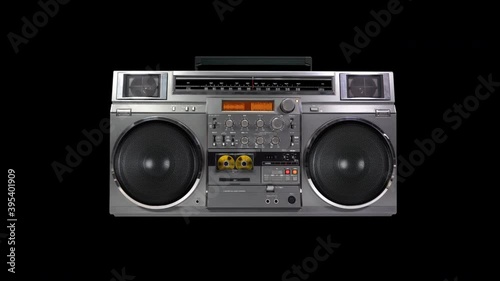 Retro music black background with radio boombox playing a golden cassette tape. Seamless loop