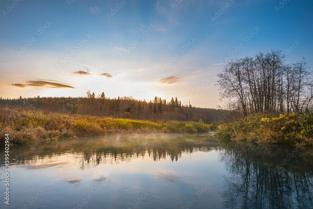 Beautiful autumn morning in the woods with sunshine and fog from the river.