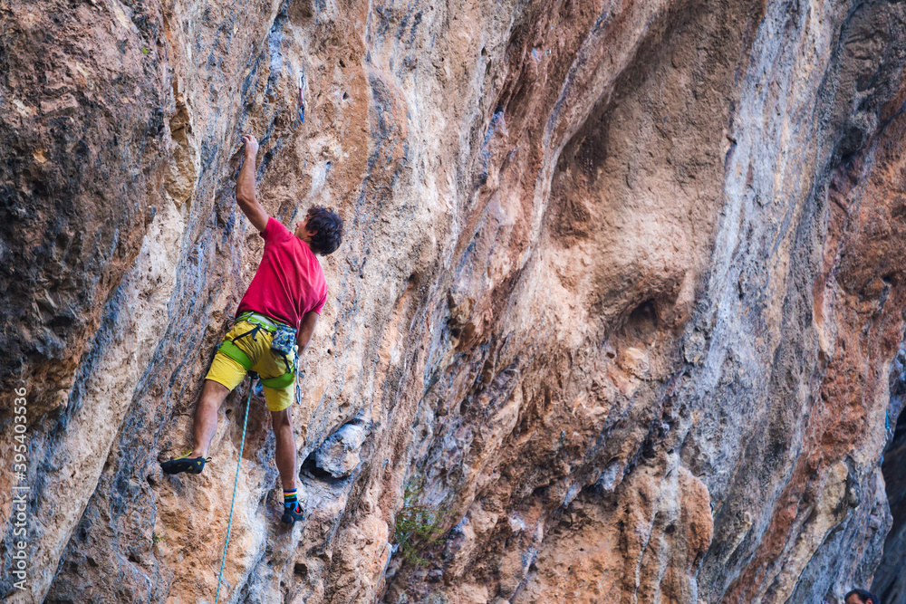 Climber overcomes a difficult climbing route on a natural terrain.
