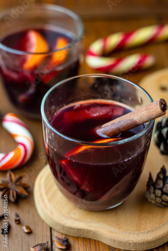 traditional winter hot alcohol cocktail in transparent glass, christmas homemade mulled wine or grog or punch on dark wooden table