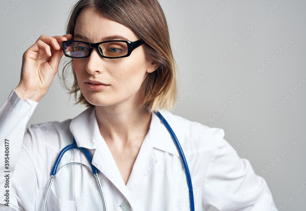 Portrait of a female doctor in a medical gown and a blue stethoscope Portrait of a female doctor in a medical gown and a blue stethoscope