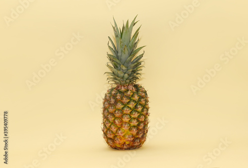 Ripe juicy ripe pineapple on a light yellow background. Minimalism. Tropical fruit