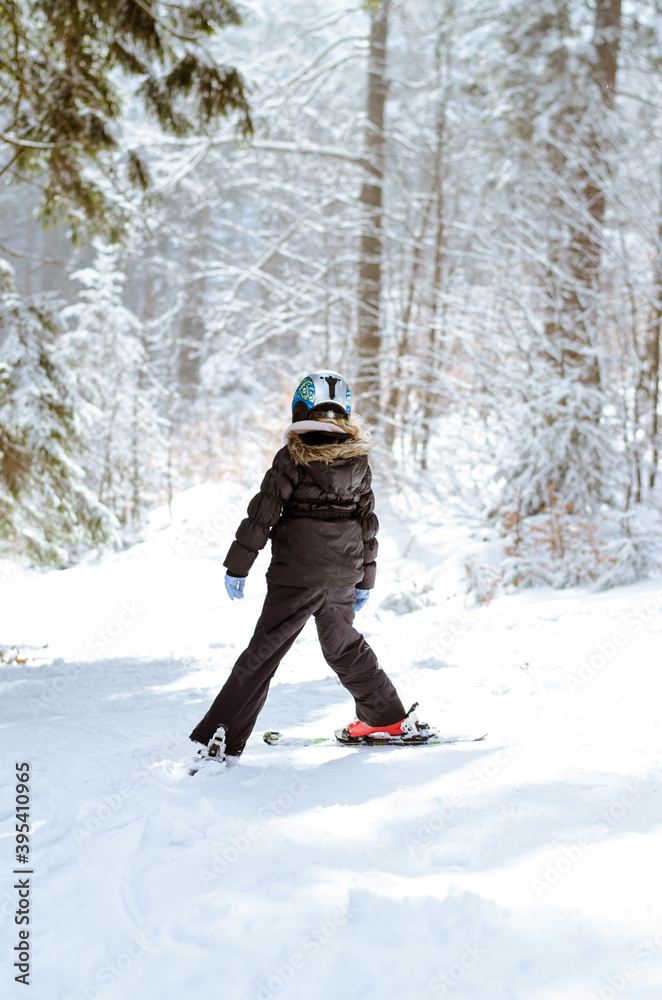 child having sport activity of skiing in winter woodland