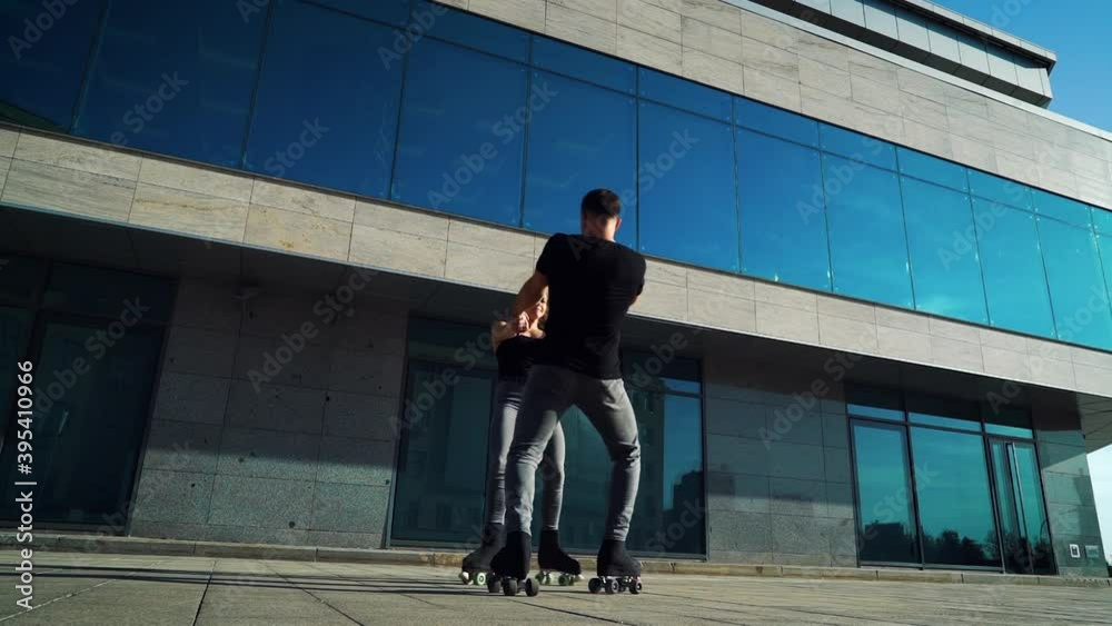 Roller skaters failed to do extreme stunt. Man and woman holding hands and spinning, female trying to lift leg. Concept of sport Roller skaters failed to do extreme stunt. Man and woman holding hands and spinning, female trying to lift leg. Concept of sport