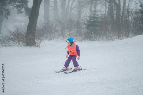 child having sport activity of skiing in winter woodland