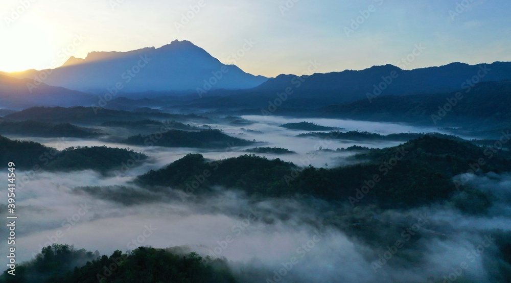 Beautiful Landscape of misty foggy with mount kinabalu during sunrise
