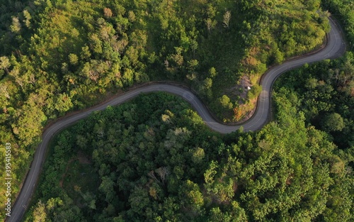 Aerial view of hilly region borneo showing forests, roads and slopes.