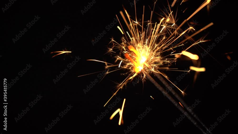 Firework sparklers lighting at new year party, close up. Holidays. Festive background. Gold sparks of a sparkler on a dark background. Merry Christmas. Firework sparklers lighting at new year party, close up. Holidays. Festive background. Gold sparks of a sparkler on a dark background. Merry Christmas.
