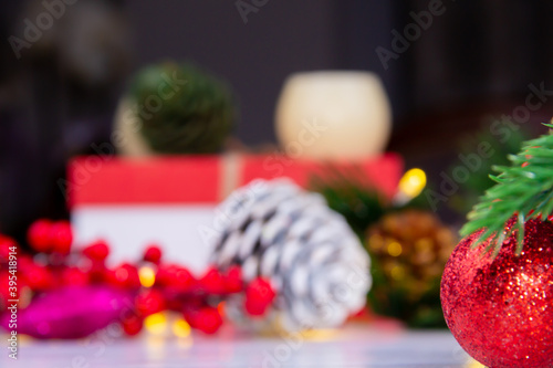 
Red shiny Christmas ornament standing on white background in front of cones, gift box and New Year decorations. It is christmas concept!
 (ID: 395418914)