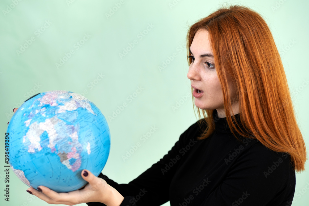Portrait of a sad worried young woman holding geographic globe of the world in her hands. Travel destination and planet protection concept. Portrait of a sad worried young woman holding geographic globe of the world in her hands. Travel destination and planet protection concept.