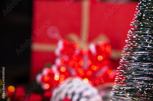 
close-up of a snowy Christmas tree with Christmas decorations behind (ID: 395419360)