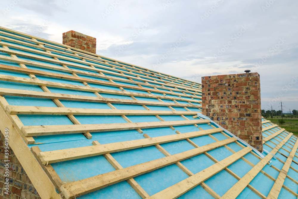 Obraz premium Aerial view of a wooden roof frame of brick house under construction.