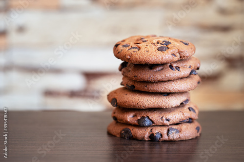 Stack of oatmeal cookies with chocolate on wooden table