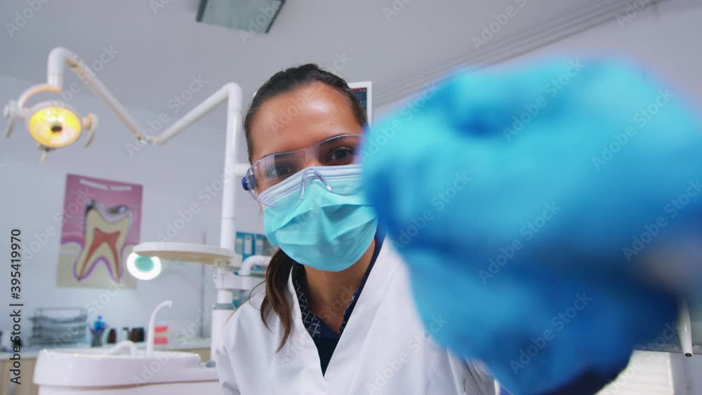 Dentist technician drilling patient tooth in dental clinic, person pov. Doctor with mask holding tools examining woman with toothache sitting on stomatological chair, nurse preparing tools for surgery Dentist technician drilling patient tooth in dental clinic, person pov. Doctor with mask holding tools examining woman with toothache sitting on stomatological chair, nurse preparing tools for surgery