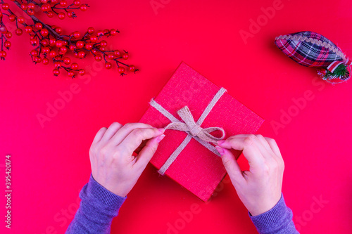 girl opening red christmas gift box in red new year concept (ID: 395420174)