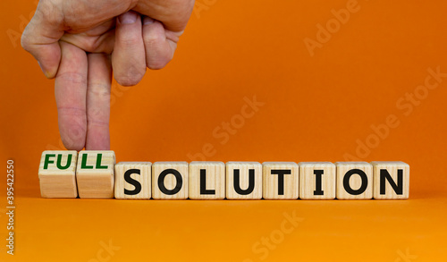 Time to full solution. Hand turns cubes and changes words 'solution' to 'full solution'. Beautiful orange background. Business and full solution concept. Copy space. photo