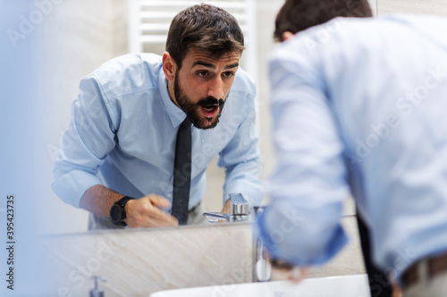 Businessman washing his face in bathroom.