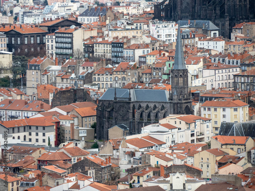 View on the roofs of Clermont-Ferrand, in Auvergne region, France. We can see the bell tower of a church. View on the roofs of Clermont-Ferrand, in Auvergne region, France. We can see the bell tower of a church.