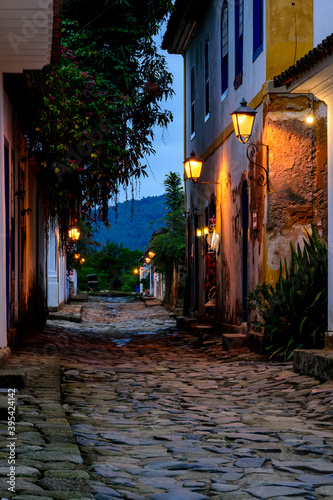 Fototapeta Naklejka Na Ścianę i Meble -  Dusk view of the city of Paraty with its old colonial style houses, lanterns and the brightness and colors of the city lights reflected in the cobbled streets