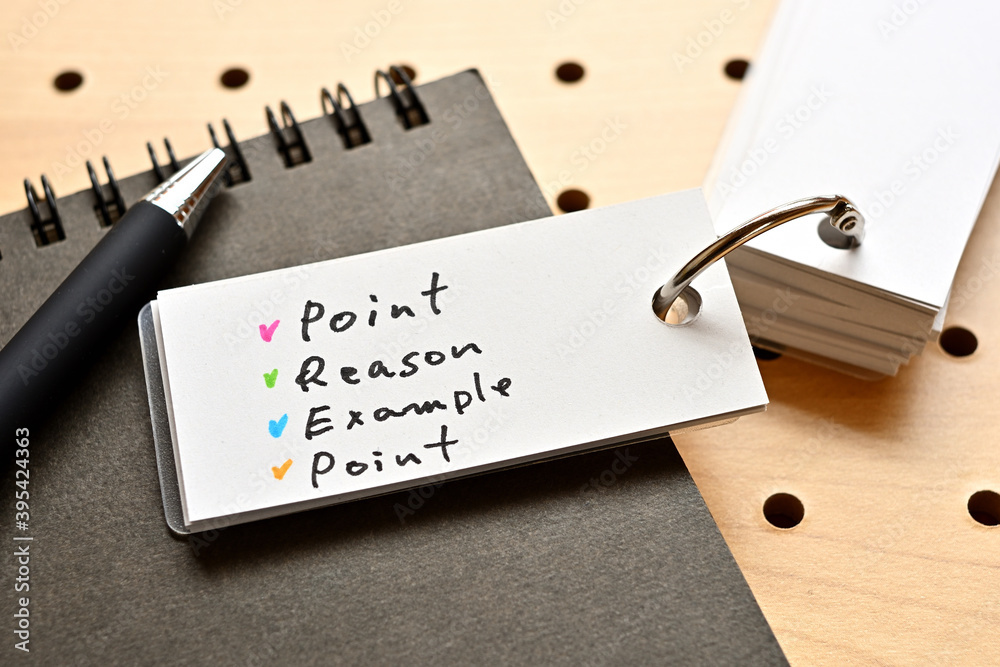 There is a wordbook on a desk with randomly placed dummy papers on it