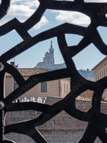 View on Notre Dame de la Garde in Marseille, a Catholic basilica. The monument is visible behind an artistic structure. Marseille is located in southern France.