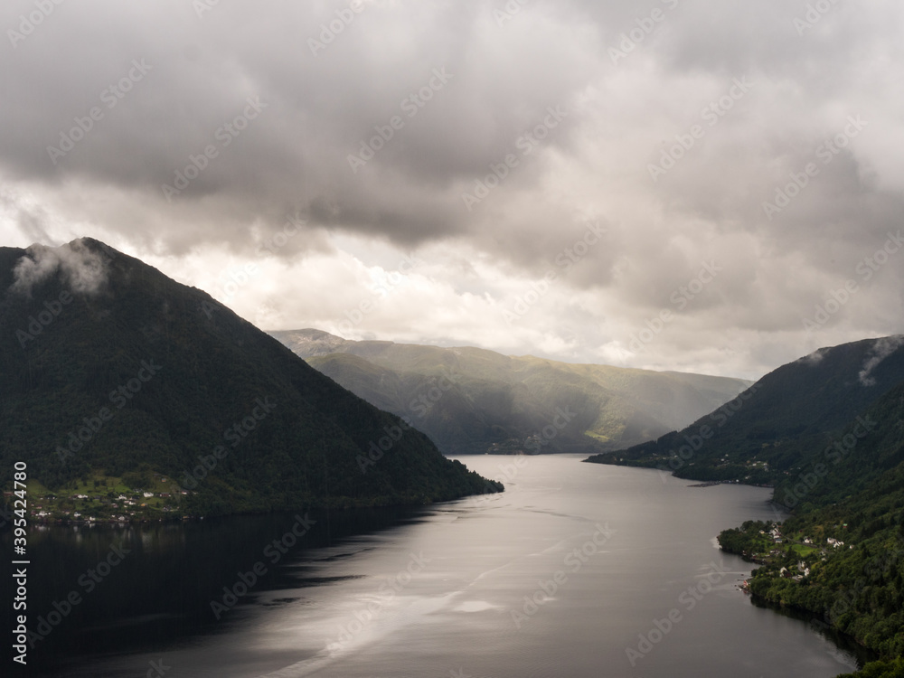 View on a fjord in Norway, northern Europe, near Bergen. Cloudy sky and little light. View from the top of a mountain. 