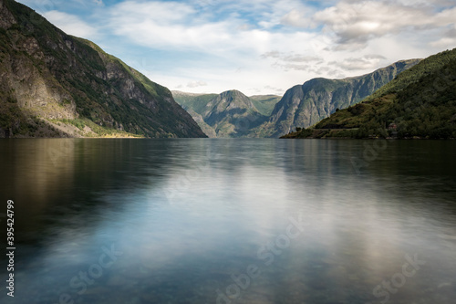 View on a fjord from the village of Flåm, Norway, Europe. Photographed in summer. Some clouds in the sky. Nobody.