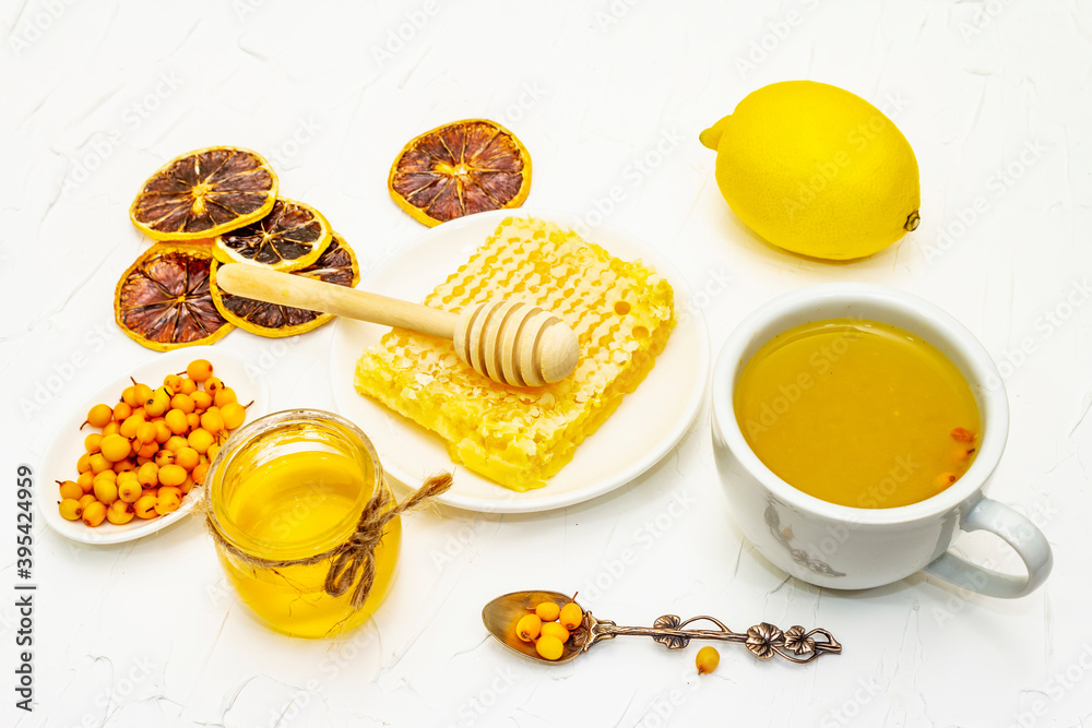 Fototapeta premium Healing sea-buckthorn tea with honeycombs and lemon