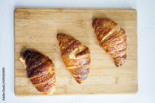 Close up of golden croissants on a wooden tray