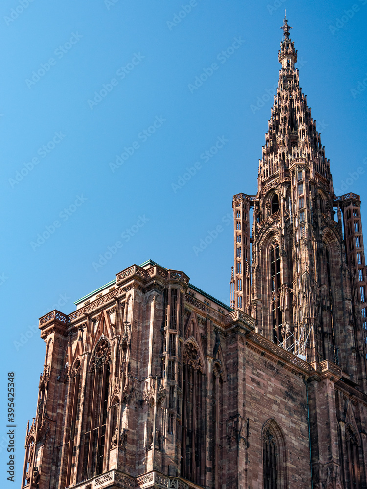 View on the tower of the Strasbourg Cathedral (French: Cathédrale Notre-Dame de Strasbourg), a Catholic cathedral in Strasbourg, Alsace in France. Blue sky and sunny day.