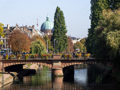 View on the Ill river in Strasborug, a city located in eastern France. In the background is the dome of the church of Saint-Pierre-le-Jeune in Strasbourg. Bridge in the foreground. photo