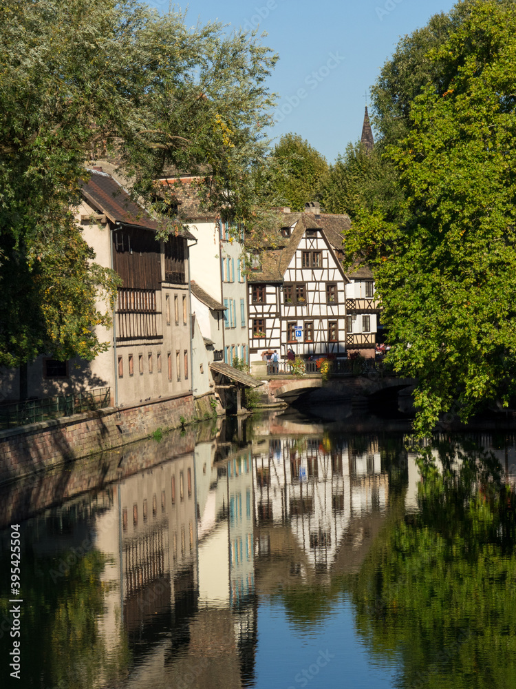 View a river in Strasbourg. Relfet of a typical house in the water of the river Ill. Half-timbered house. Strasbourg is a city located in the east of France. View a river in Strasbourg. Relfet of a typical house in the water of the river Ill. Half-timbered house. Strasbourg is a city located in the east of France.