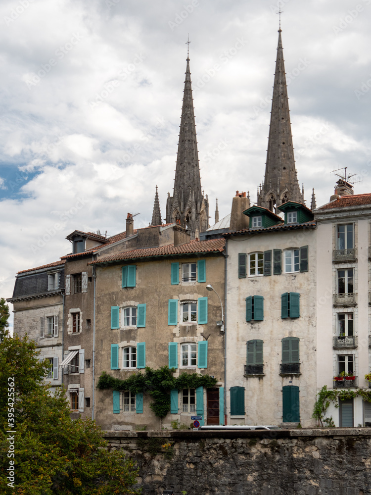 Buildings in the city of Bayonne. A city in the department of Pyrénées-Atlantiques, southern France. Cloudy sky. Cathedral towers in the background.